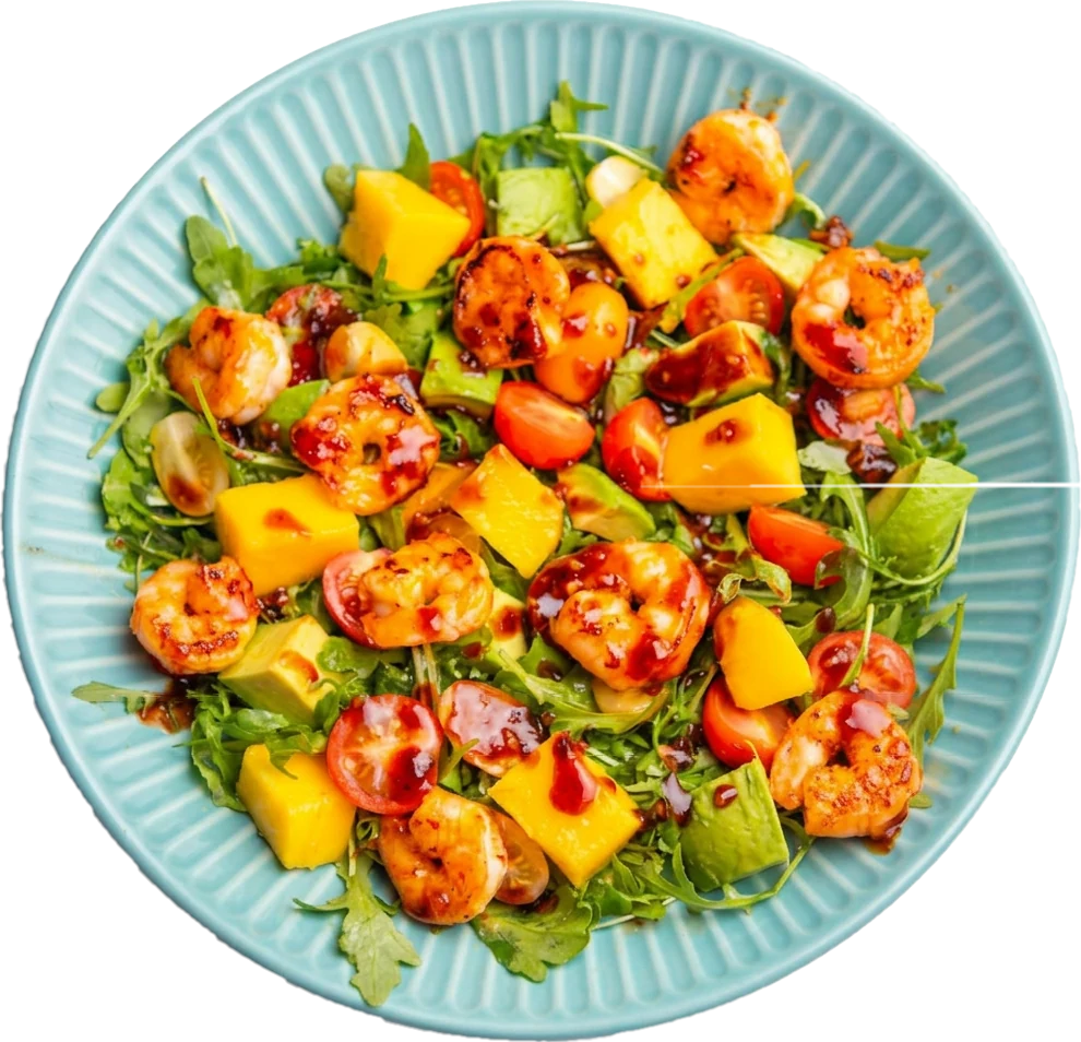 Mango and prawn salad with sweet chilli sauce on a blue plate, photographed from above